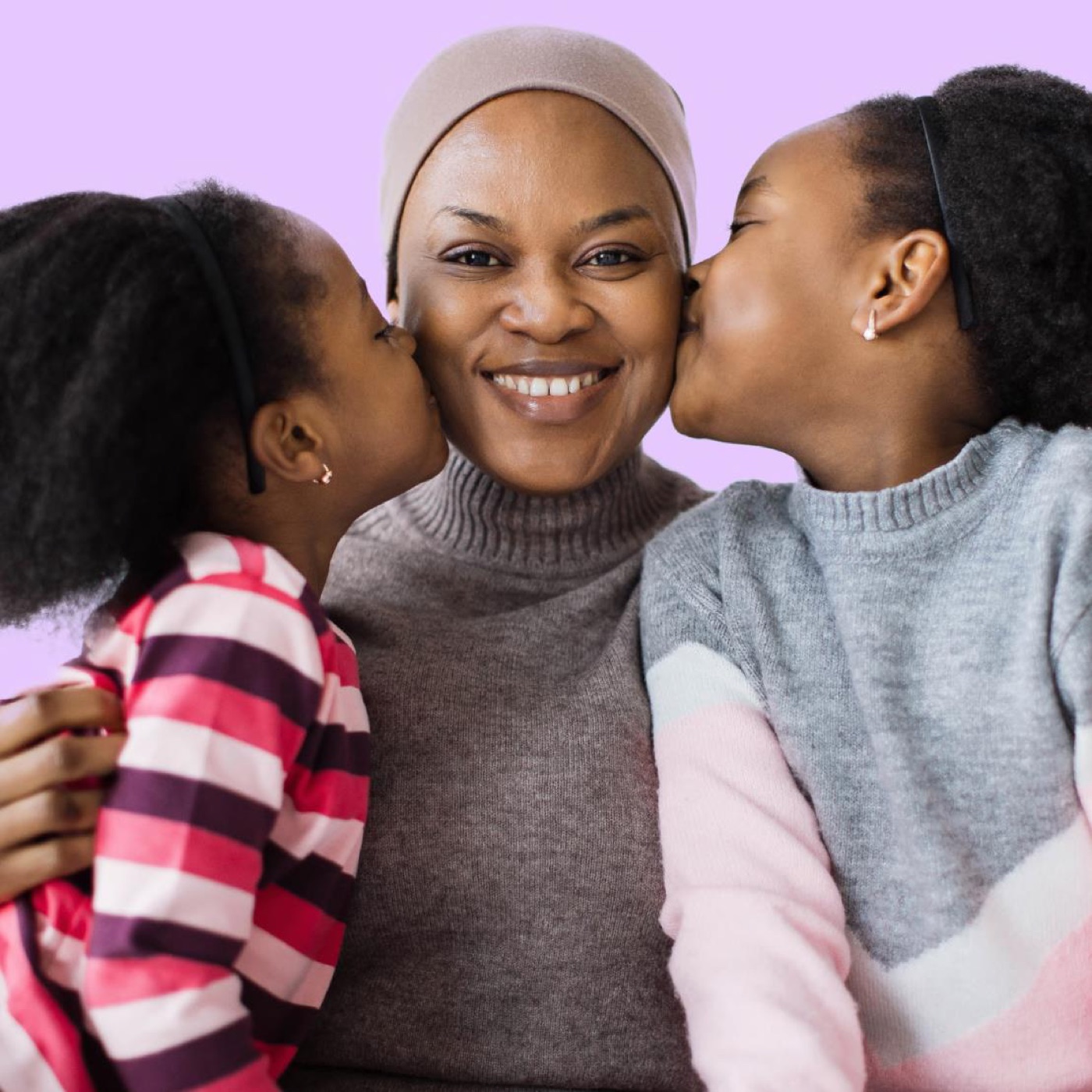 A mother being kissed by her children